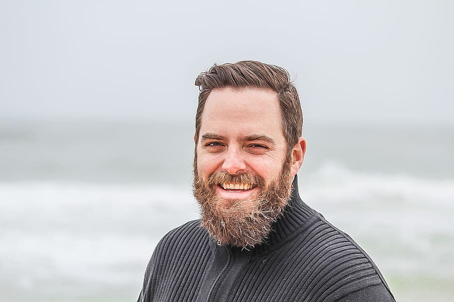 Man Wearing Black Zip-up Jacket Near Beach Smiling at the Photo, adult, beach, beard, casual, facial expression, facial hair, fashion, fine-looking, focus, fun, good-looking, happy, man, ocean, outdoors, person, portrait, relaxation, sea, smiling, summer, wear, HD wallpaper