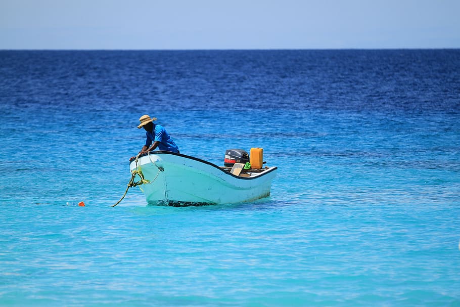 Hombre de pie en un bote blanco durante el día, pescador, bote, pesca