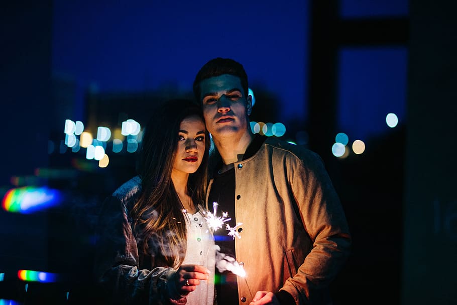 Man and woman holding sparklers during nighttime, dark, night, lights ...