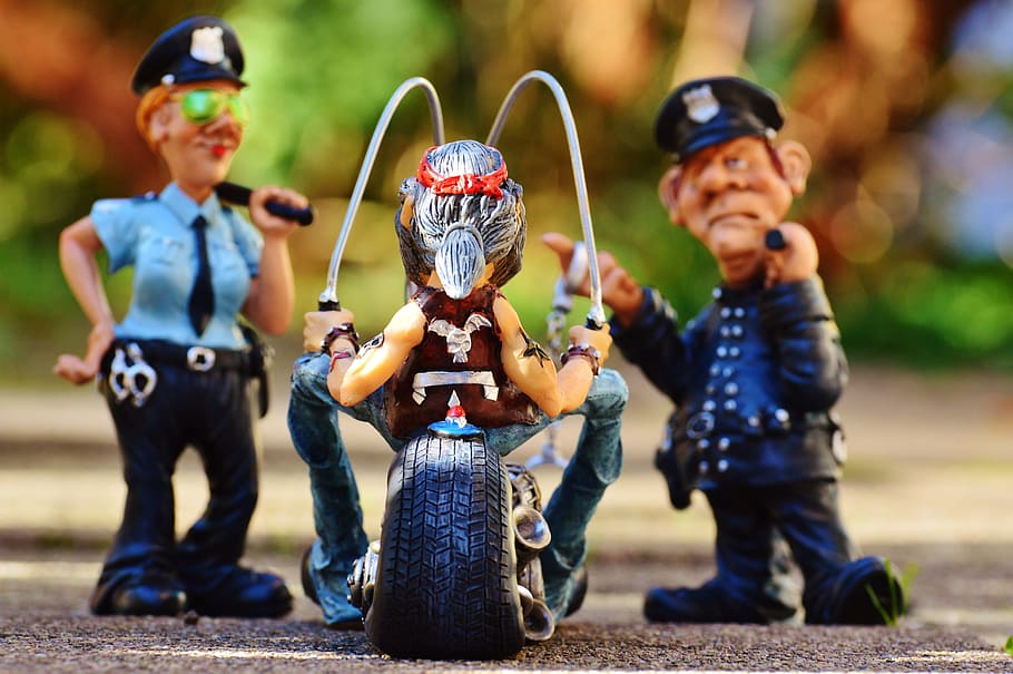 Two police toys in front of man riding motorcycle toy, biker, police ...